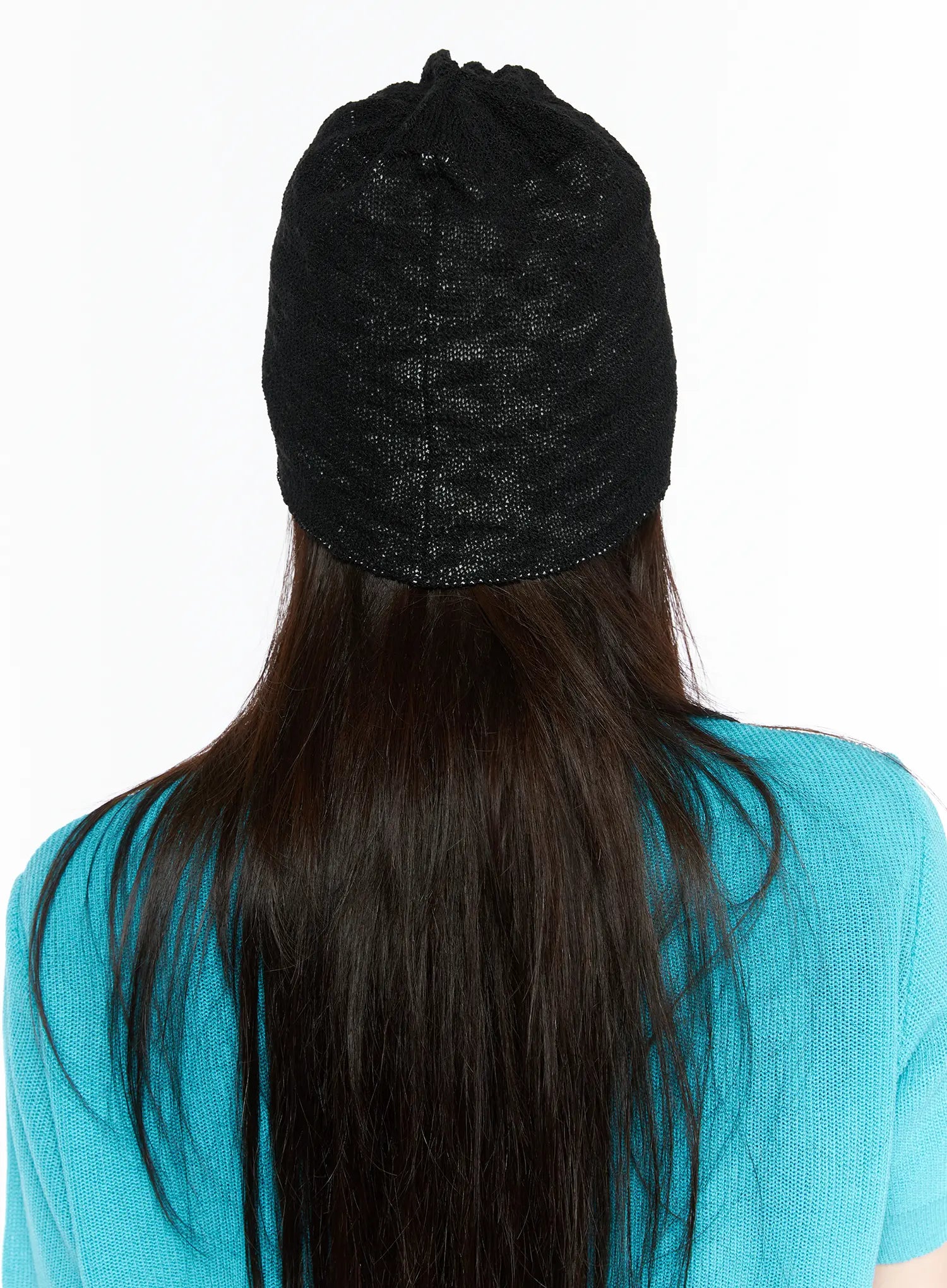Brooks Bear Beanie IL503 Black back view on model wearing teal cardigan, plain black open-weave knit texture visible from behind