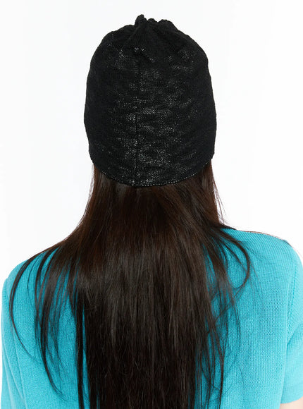 Brooks Bear Beanie IL503 Black back view on model wearing teal cardigan, plain black open-weave knit texture visible from behind