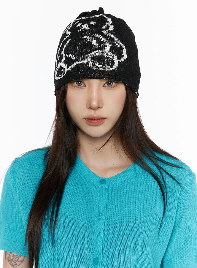 LEWKIN Brooks Bear Beanie IL503 Black front view on model wearing teal knit cardigan, white bear graphic intarsia knit beanie pulled low over forehead