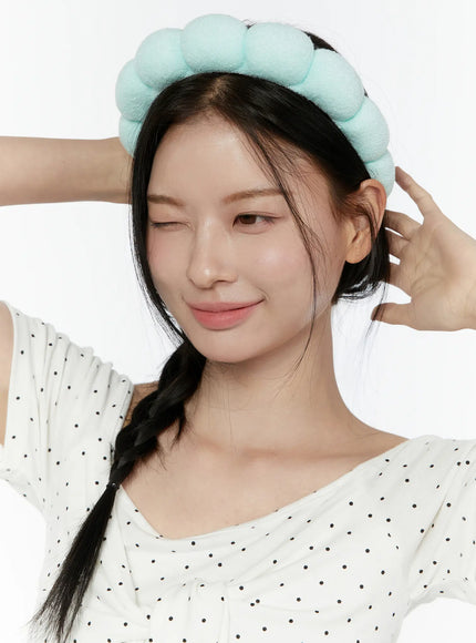 Bubble Headband IL506 Mint close-up front model wearing mint green puffy bubble headband hands raised adjusting headband winking