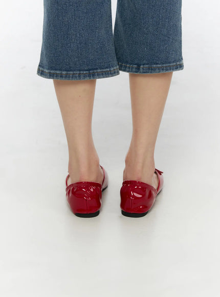 Buckle Detail Flats CU530 Red back shot on model wearing blue denim cropped jeans, showing patent leather heel counter with ruched elastic back