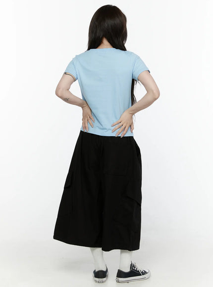Butterfly Graphic Crop Tee IL521 Light blue back view on model showing plain clean back and cropped hemline styled with black wide-leg cargo pants