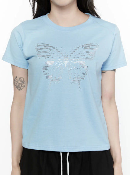Butterfly Graphic Crop Tee IL521 Light blue close-up front detail on model showing silver rhinestone butterfly graphic print on cotton fabric