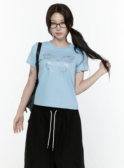LEWKIN Butterfly Graphic Crop Tee IL521 Light blue front view on model wearing glasses and ponytail styled with black wide-leg pants and backpack