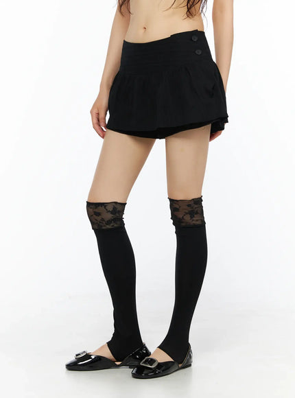 Button Flare Mini Skirt CU530 Black front close-up shot on model from waist down showing button closure, pleated flare skirt layer over built-in shorts