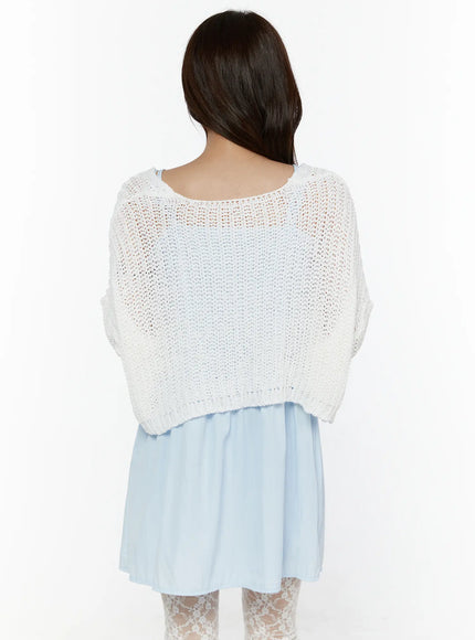Button Knit Cardigan CL508 White back shot on model showing open-knit texture, wide dropped shoulder, cropped back hem, layered over light blue mini dress with lace tights