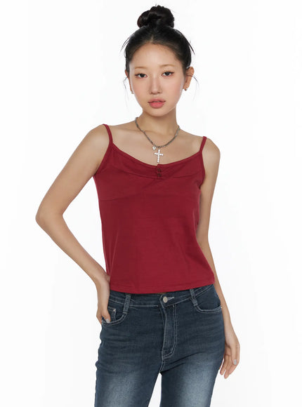 Button Sleeveless Top CL510 Red front view on model wearing bun updo with cross necklace accessory styled over dark wash skinny jeans