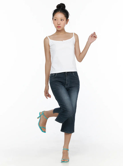 Button Sleeveless Top CL510 White full-body shot on model in playful one-leg-raised pose styled with cropped flare jeans and teal heeled sandals