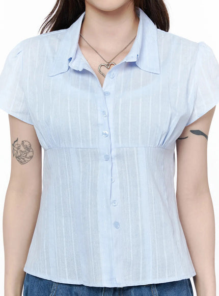 Button Up Linen Summer Blouse IL506 Light blue three-quarter front shot on model with arms crossed showing fitted waist and stripe fabric