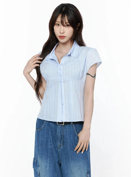 Button Up Linen Summer Blouse IL506 Light blue side-angle shot on model with hands clasped showing fitted silhouette and sheer stripe fabric