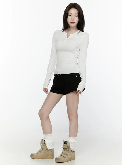 Button-Up Long Sleeve Top IL521 White angled three-quarter front shot on model with downward gaze, slim-fit ribbed long sleeve with henley collar, paired with black shorts