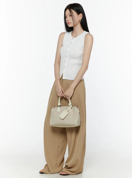 Button-Up Tank Top IL506 White side shot on model holding cream handbag at waist level, full-length styling with wide-leg trousers