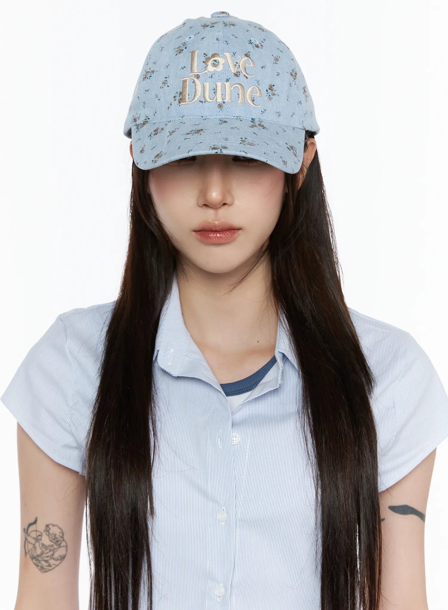 LEWKIN Camden Flower Ball Cap IL503 light blue front view on model wearing brim low over eyes with blue striped shirt, denim floral pattern with cream Love Dune embroidery