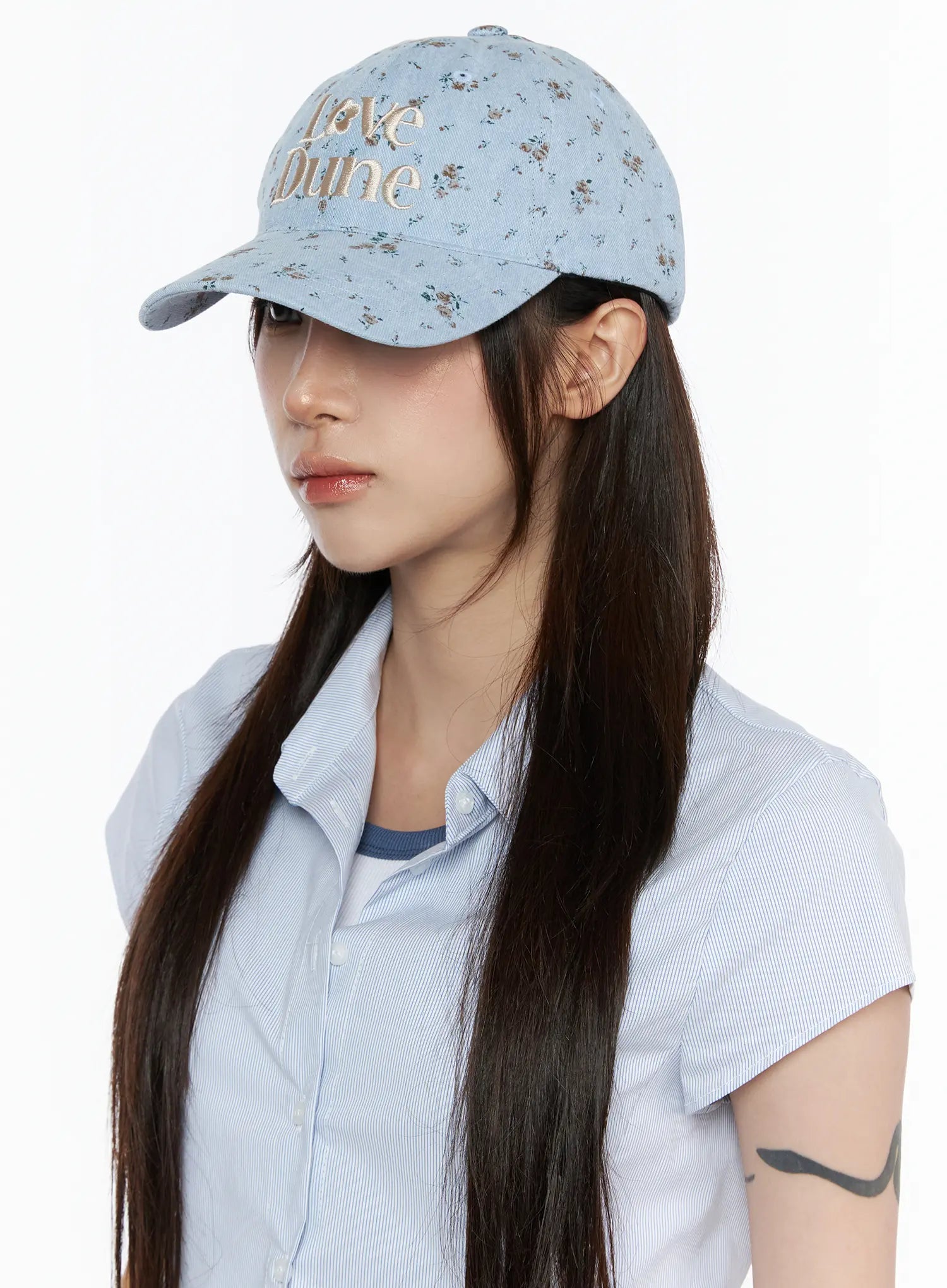 Camden Flower Ball Cap IL503 light blue three-quarter front view on model with long dark hair, floral denim fabric and cream Love Dune embroidery detail visible