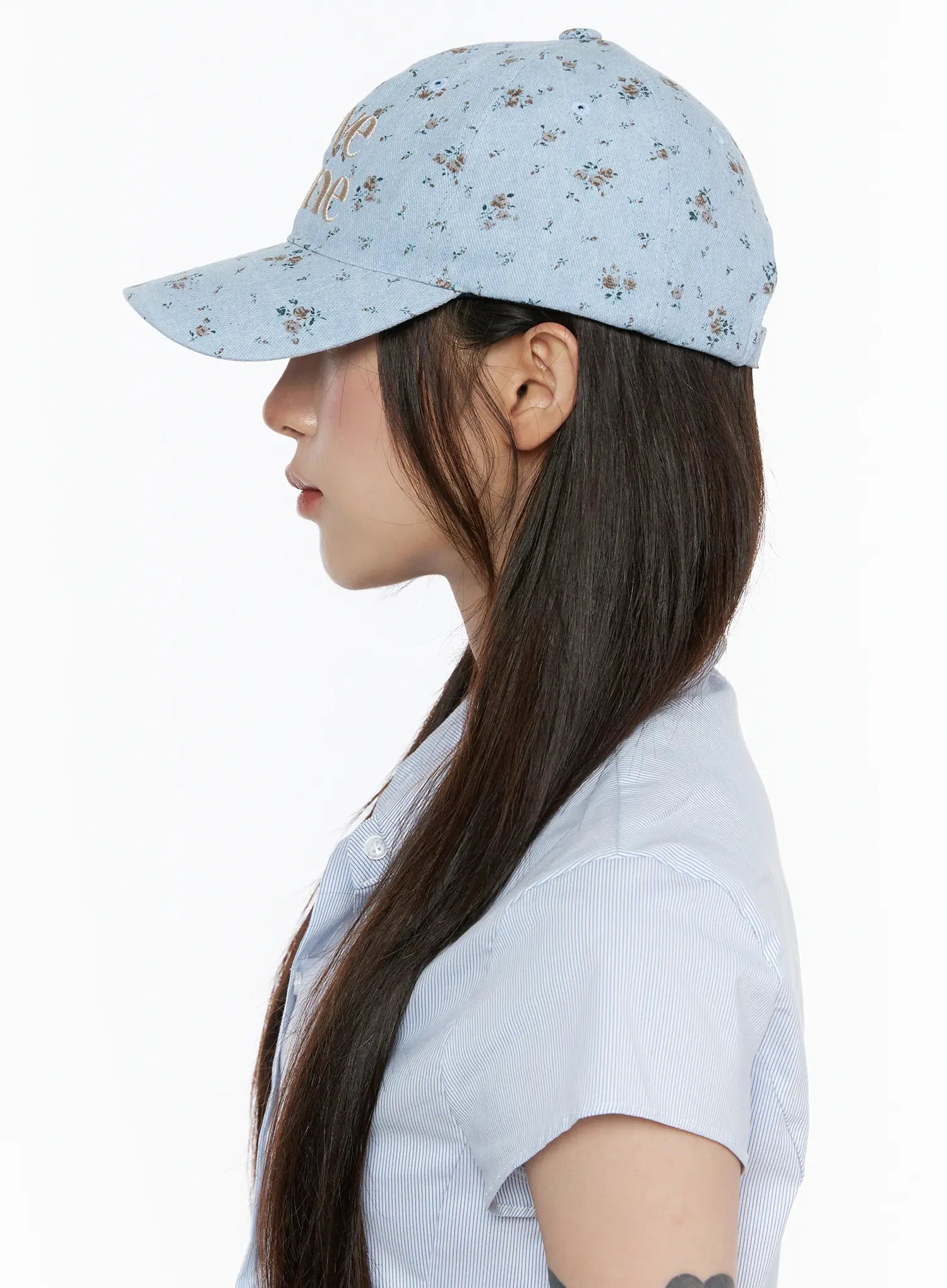 Camden Flower Ball Cap IL503 light blue side profile view on model facing left, showing floral denim cap structure and brim shape styled with striped shirt