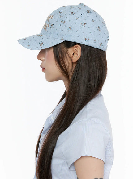 Camden Flower Ball Cap IL503 light blue side profile view on model facing left, showing floral denim cap structure and brim shape styled with striped shirt