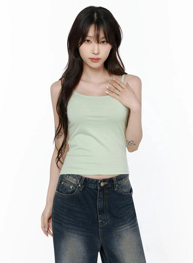 Cami Tank Top IL506 Mint front shot on model half-body pose, hand on chest, scoop neck with thin spaghetti straps, ribbed cotton fabric, paired with dark denim