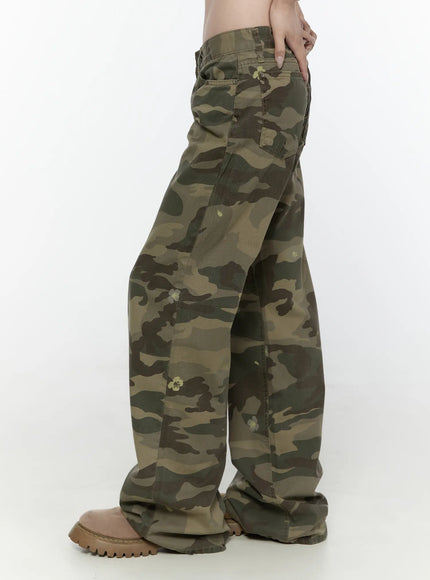 Camo Cargo Trousers IL522 Dark green side view on model showing low-rise waistband, side pocket, wide-leg drape, and flower print on camo