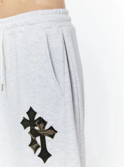 Camo Cross Patch Bermuda Shorts IU524 Light gray close-up side detail of layered black and camo cross patch near pocket opening with ruched elastic drawstring waistband