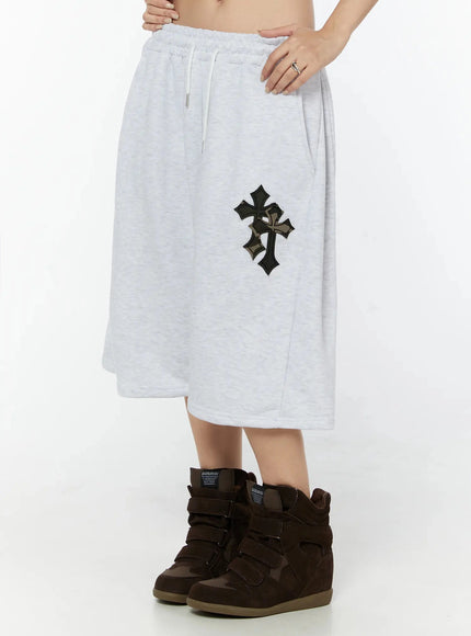 Camo Cross Patch Bermuda Shorts IU524 Light gray side view on model showing wide-leg silhouette and back of waistband, hand resting on hip, worn with brown wedge sneakers