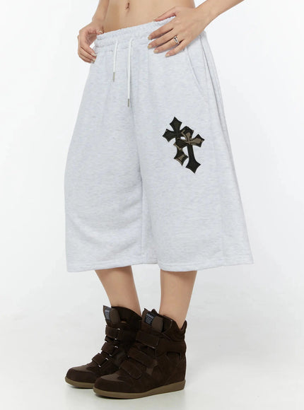Camo Cross Patch Bermuda Shorts IU524 Light gray side view on model, cropped waist shot showing wide-leg silhouette, cross patch detail and white drawstring waist