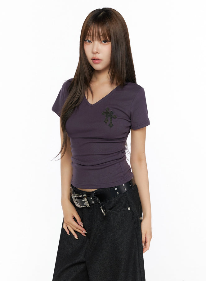 Camo Cross V-Neck Side Shirring Slim Tee IL515 Purple front model shot three-quarter view, slim ribbed fit with layered cross patch on chest, paired with black pants