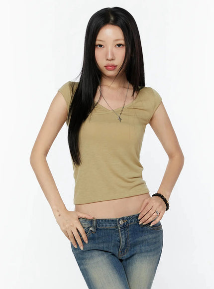 Cap Sleeve V-Neck Top IL516 Beige front half-body shot model with hands on hips wearing fitted V-neck cropped top with silver cross necklace