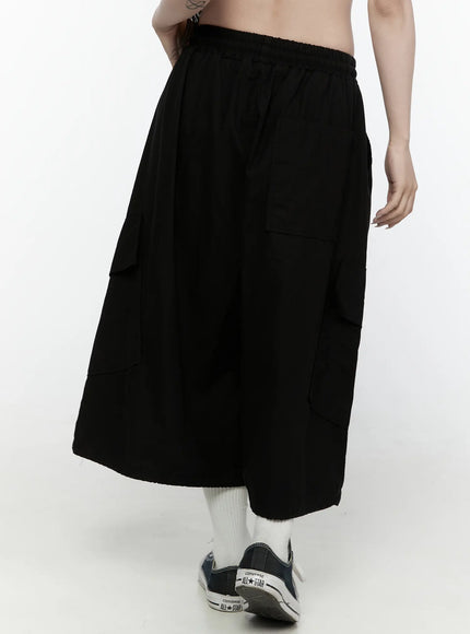 Cargo Pocket Shorts IL521 Black back-angle shot on model showing rear cargo pockets elastic waistband raw hem and Converse sneakers