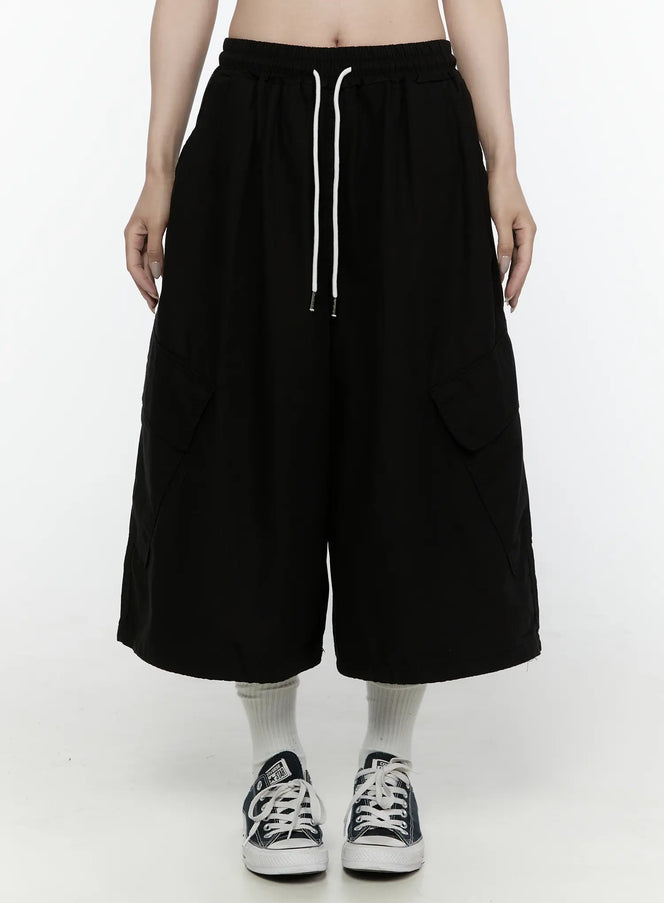 LEWKIN Cargo Pocket Shorts IL521 Black M/L front shot on model cropped view showing elastic drawstring waist and wide-leg silhouette with cargo pockets