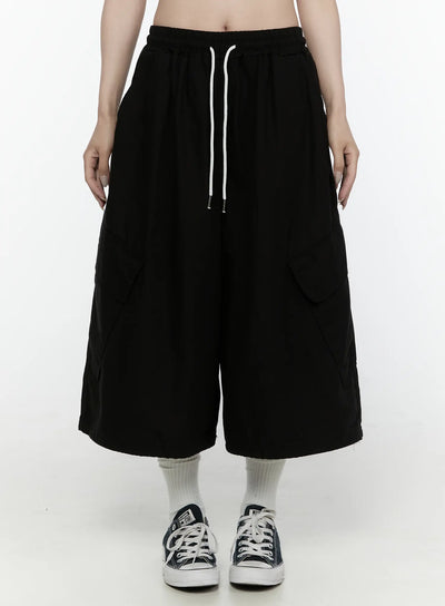LEWKIN Cargo Pocket Shorts IL521 Black M/L front shot on model cropped view showing elastic drawstring waist and wide-leg silhouette with cargo pockets