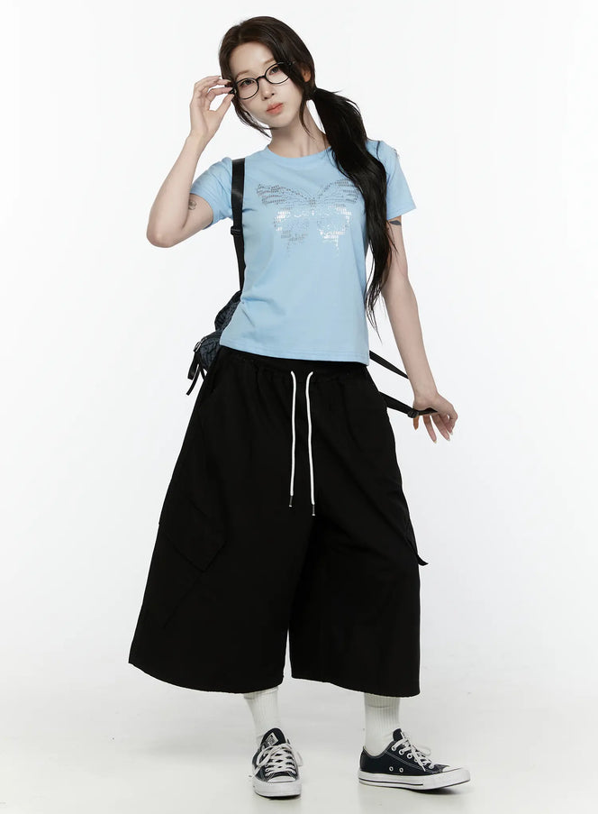 Cargo Pocket Shorts IL521 Black full-body front shot on model styled with blue butterfly graphic tee bag and Converse sneakers