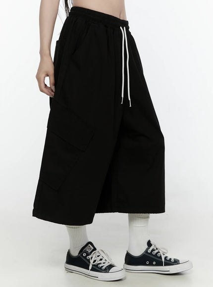 Cargo Pocket Shorts IL521 Black side shot on model showing large cargo pocket detail elastic waistband and white contrast drawstring cord