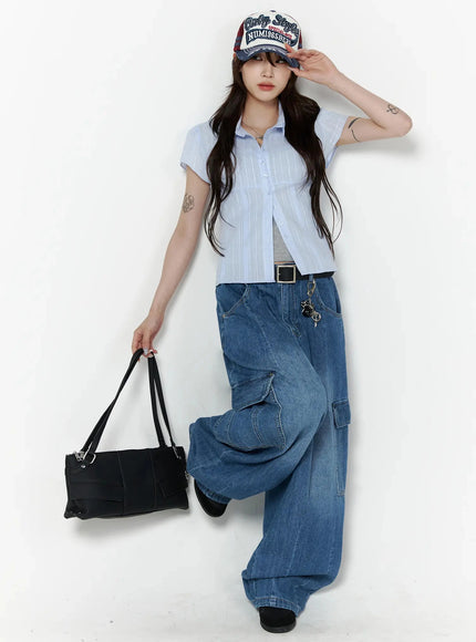 Carla Wide Cargo Jeans IL506 Blue full-body front shot on model in light blue shirt and cap holding black bag, dynamic walking pose with belt charm