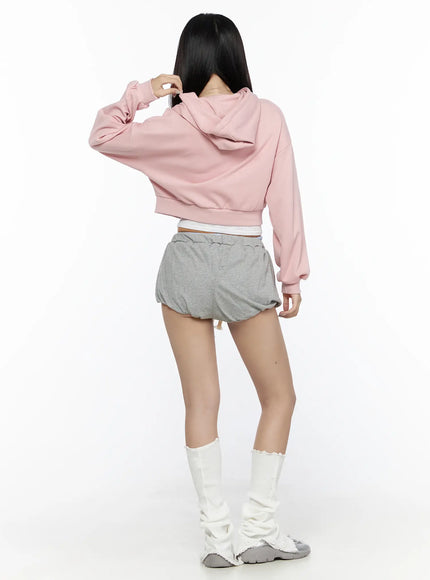 Casual Cropped Hoodie CL527 Light pink back shot on model size S/M revealing clean back panel cropped length ribbed hem styled with gray shorts and white leg warmers