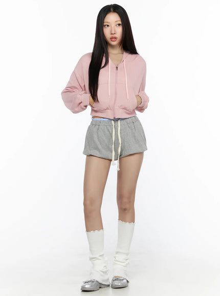 Casual Cropped Hoodie CL527 Light pink full-body front shot on model size S/M zip-up crop hoodie with drawstring styled with gray shorts and white leg warmers