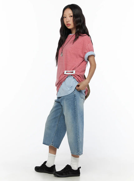 Casual Oversized T-Shirt CL513 Pink side model shot showing layered light blue underlayer, belt buckle detail, wide-leg jeans and black sneakers