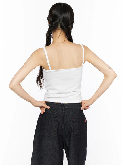 Casual Sleeveless Top CU530 White back shot on model with hands on hips, showing thin strap construction, open back, and cropped ribbed hem above dark denim waistband