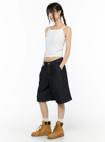 Casual Sleeveless Top CU530 White full-body side shot on model hands in pockets, cropped spaghetti-strap camisole styled with dark denim shorts and tan boots