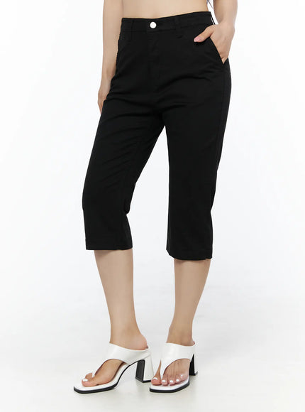 Casual Slim-Fit Capri Pants IU525 Black front three-quarter view on model with hand in pocket showing high-rise fit and wide-leg capri cut