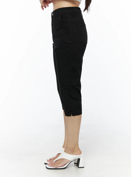 Casual Slim-Fit Capri Pants IU525 Black side view on model showing slim silhouette, side pocket, and small hem slit detail with white heeled sandals