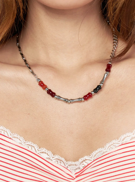 LEWKIN Celeste Link Necklace IL517 silver close-up on model neck showing red and black stone beads with bamboo-style silver tubes worn over red striped lace-trim top