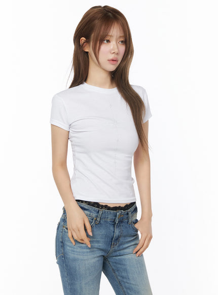 Chakra Graphic Slim Tee IL502 White three-quarter front shot model on white background with subtle star graphic print styled with low-rise blue jeans