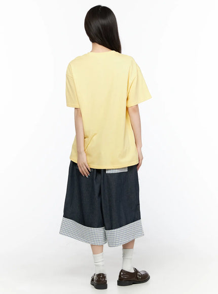 Check Back Pocket Jorts CL522 Dark blue back view on model showing plain yellow tee back, dark denim wide-leg shorts with plaid patch pocket and wide plaid check turn-up cuff