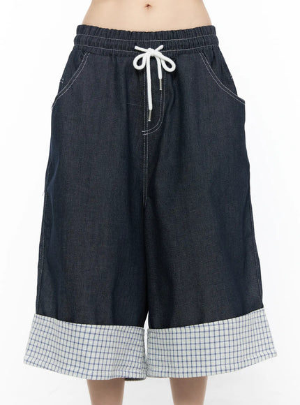 Check Back Pocket Jorts CL522 Dark blue front close-up on model showing elastic drawstring waistband, white contrast topstitching, side pockets, and wide-leg dark indigo denim fabric texture