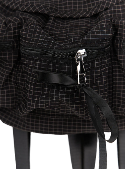 Checked Ribbon Backpack CL517 Black close-up detail of front zip pocket silver zipper pull black grosgrain strap and grid check woven fabric