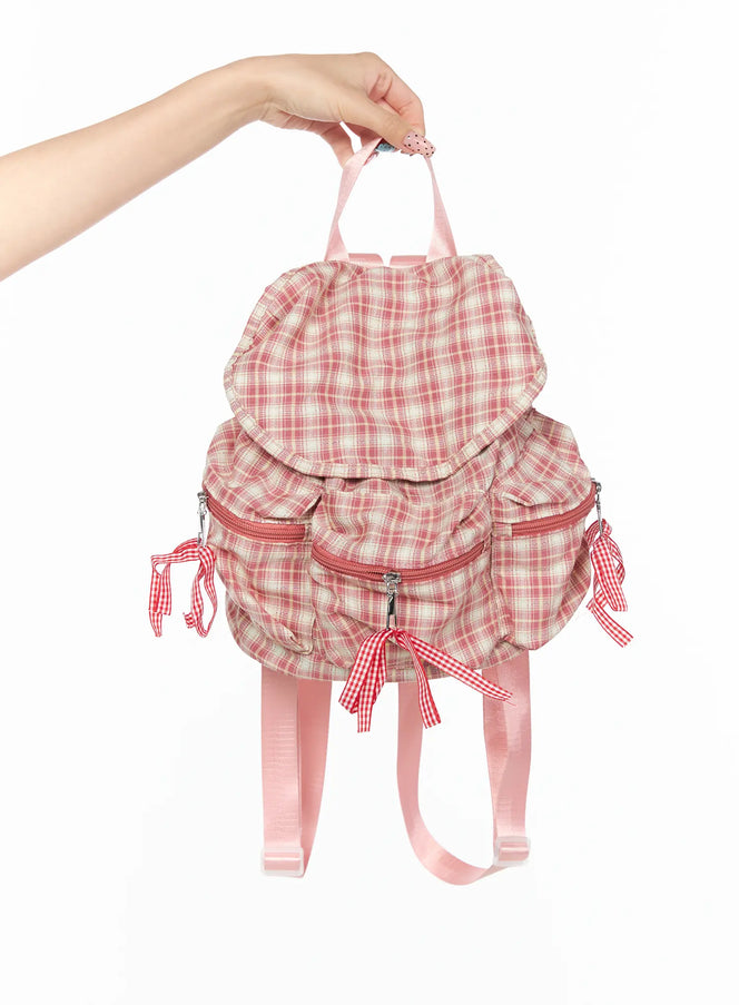 LEWKIN Checked Ribbon Backpack CL517 Pink front view held by hand showing plaid fabric ruffle flap gingham ribbon bows and pink straps
