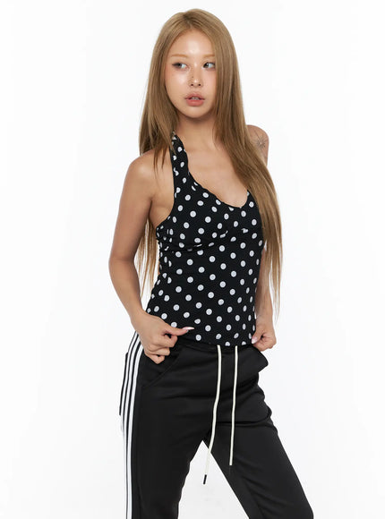 Chic Polka Dot Halter Top CU524 Black front shot on model with white polka dots, styled with black stripe track pants, angled pose