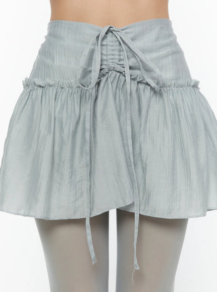 Chiffon Flare Mini Skirt CU526 Light blue front close-up detail on model showing corset-style drawstring tie, ruched panels, and crinkle chiffon fabric