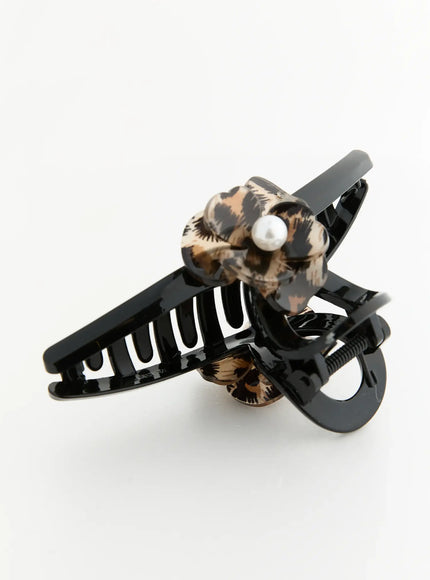 Chloe Flower Hair Clip IL503 Black three-quarter angled flat-lay showing open claw teeth, spring detail, and underside of leopard flower