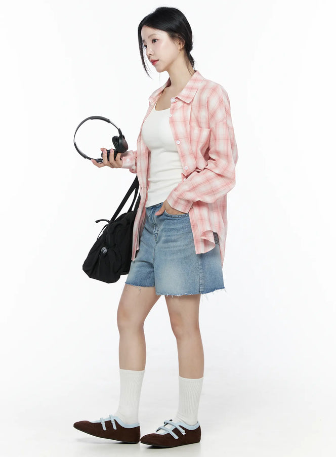 Classic Washed Jorts IU525 Blue full styling side view on model, paired with pink plaid oversized shirt, white tank top, holding headphones and black bag